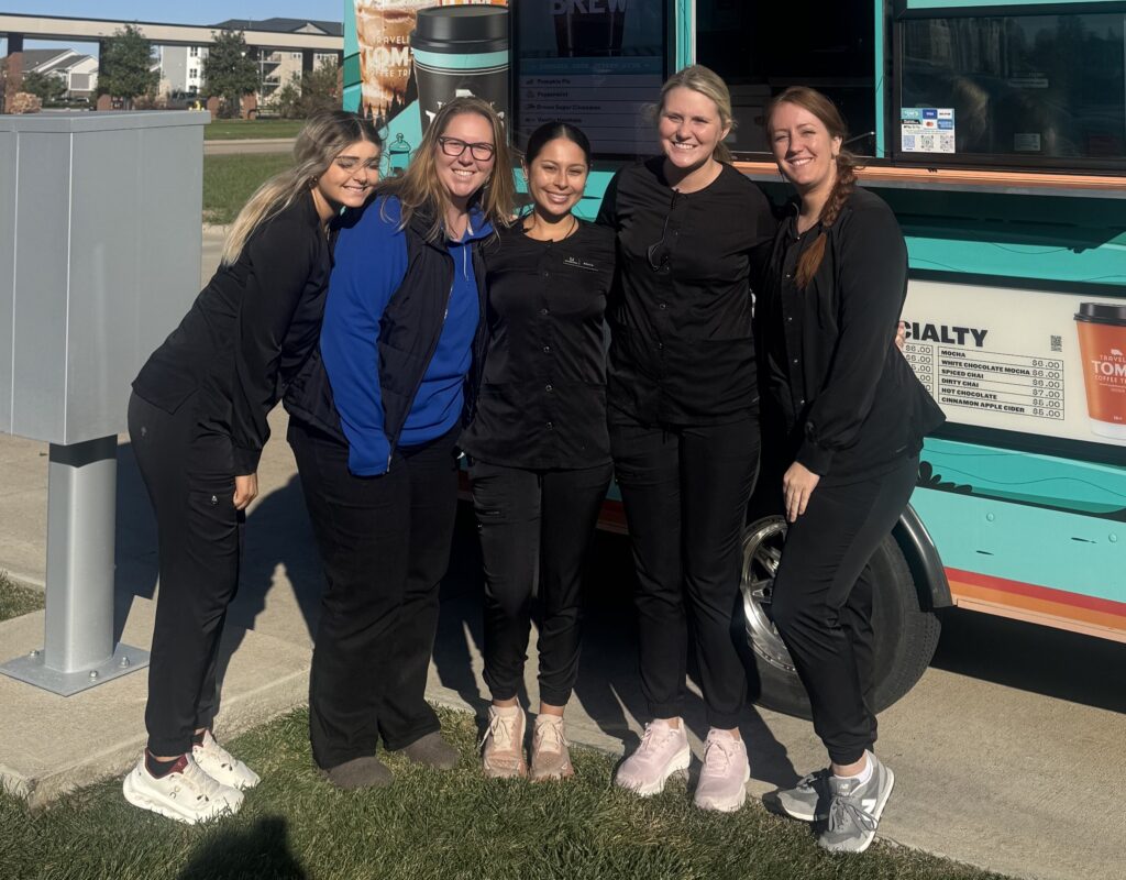 Dental team in Altoona, with arms around each other infront of a hot chocolate truck, smiling